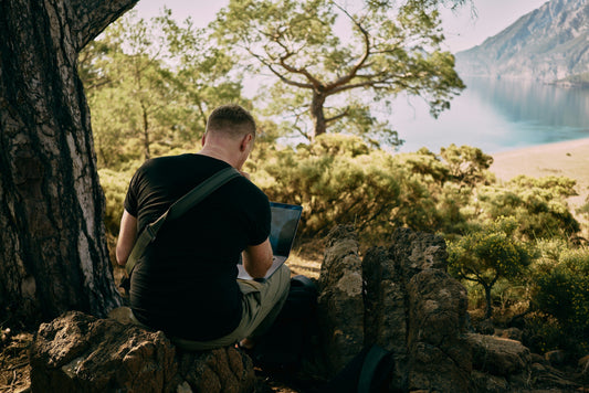 Man working while hiking on a forest trail