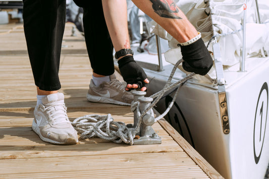 Person Wearing White Nike Sneakers Untying a Boat